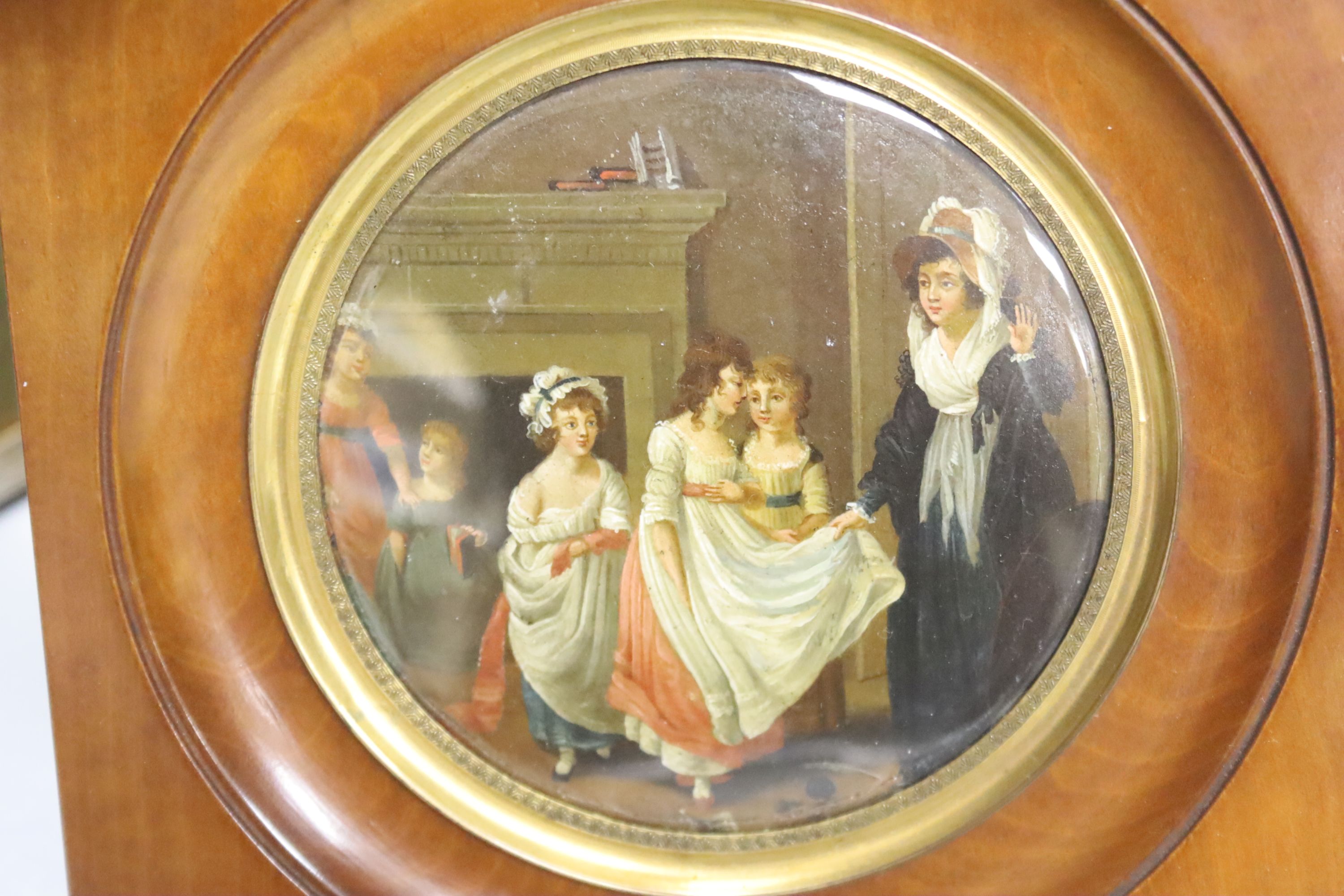 A Victorian framed miniature (snuff box lid) of children in a nursery, another miniature and three small frames, largest 10cm diameter